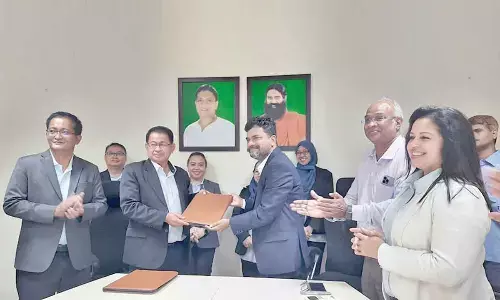Patanjali Food Limited vice-president Mallesham Poola and Datuk Bacho Bin Jansie group Managing Director Sawit Kinabalu exchanging MoU in Peddapuram on Tuesday