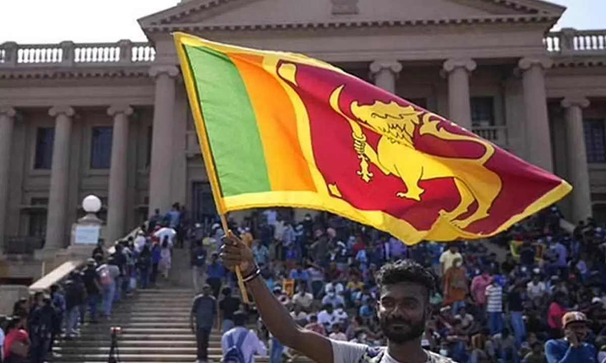 A protester waves a Sri Lankan national flag outside President Gotabaya Rajapaksas office in Colombo, Sri Lanka.