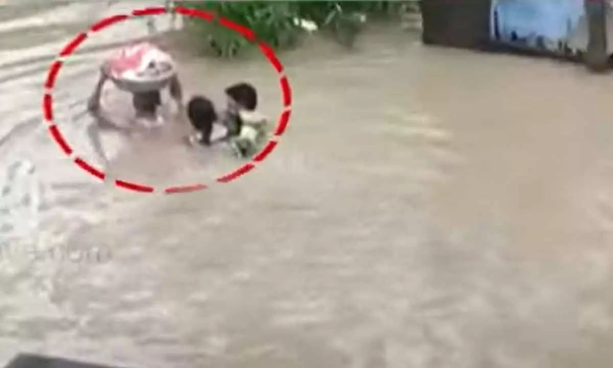 Family recreates Bahubali scene, three-month-old carried in a basket amid floods in Manthani