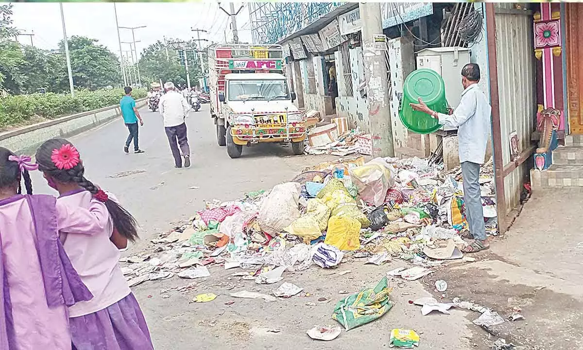 A shopkeeper dumping garbage beside a temple in Tirupati on Thursday