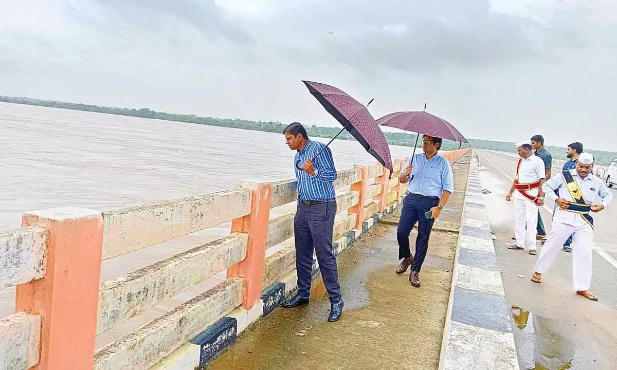 Mulugu District Collector S Krishan Aditya observing the flood level in Godavari river from high-level bridge near Pusur in Mulugu district on Friday