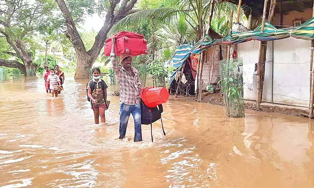 People wading through flood water to safer places in P Gannavaram mandal