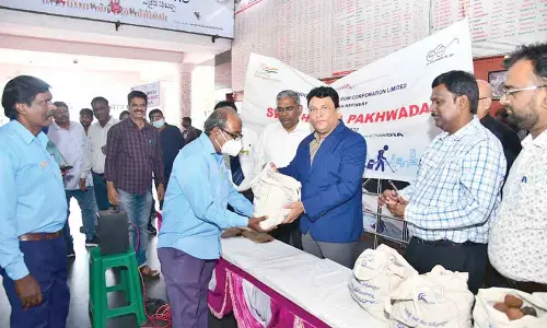 Divisional Railway Manager Anup Satpathy distributing seed balls to railway personnel in Visakhapatnam on Friday