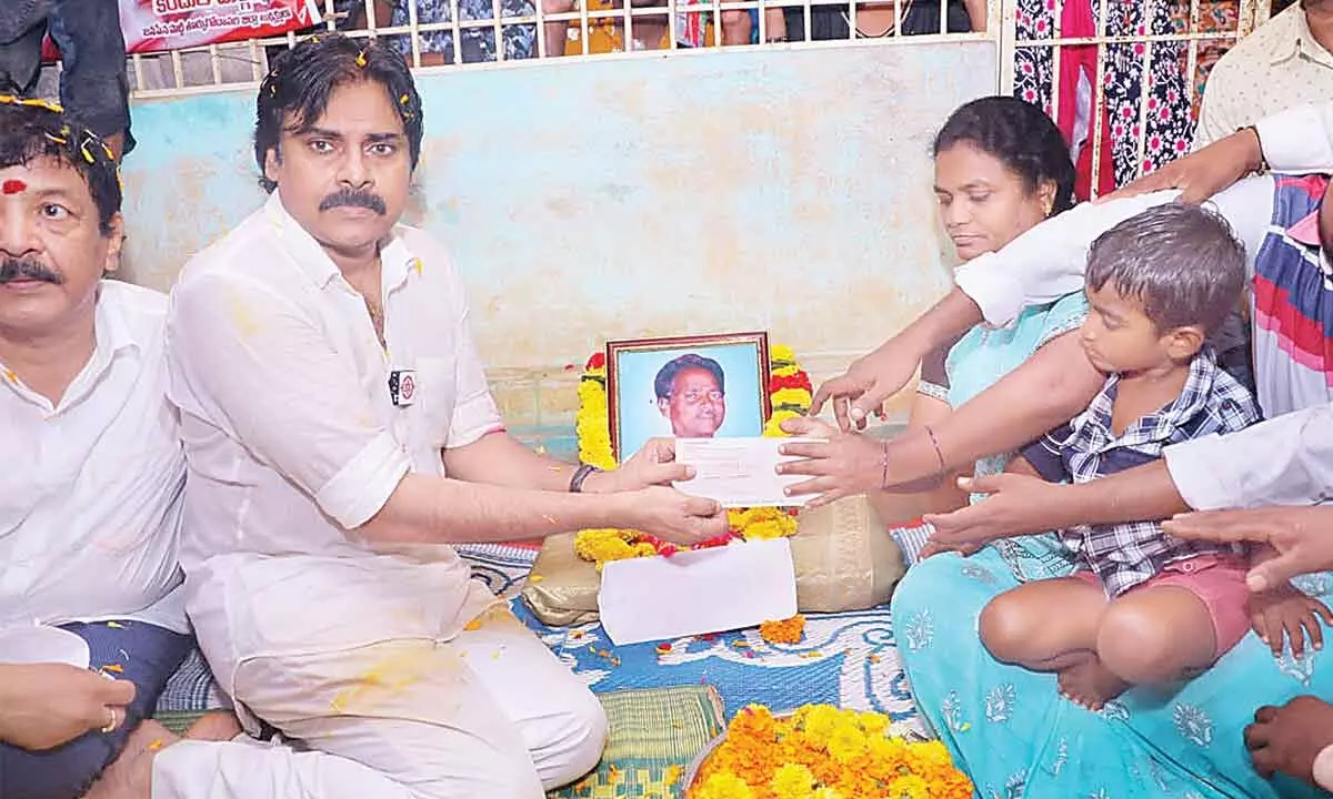 Jana Sena chief Pawan Kalyan hands over a cheque for Rs 1 lakh to the family of a tenant farmer  who died in Mandapeta on Saturday