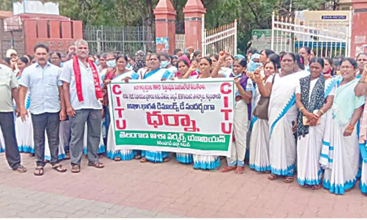 A dharna was staged by Asha workers in front of the district collector’s office in Karimnagar on Monday.