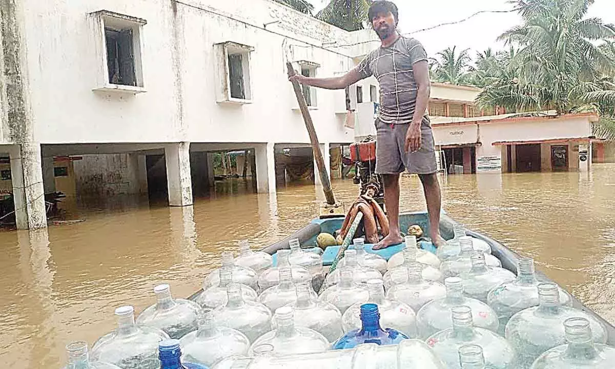 A man transporting water cans in a boat in flood-hit Konaseema district