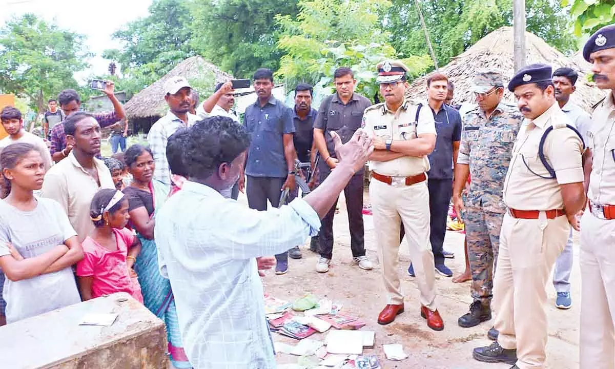 Additional ADGP Y Nagi Reddy interacting with flood victims in a tribal village in Kothagudem district on Tuesday