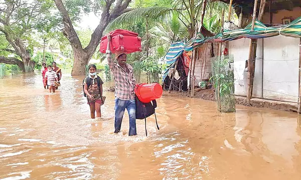 File photo of a family wading through floodwater at P Gannavaram mandal of Konaseema district