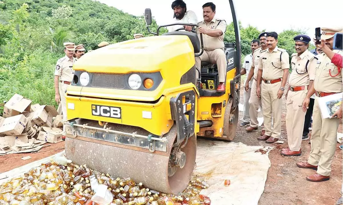 District Superintendent of Police M Ravindranath Babu crushing the NDPL liquor bottles by road roller at Tetagunta village on Friday