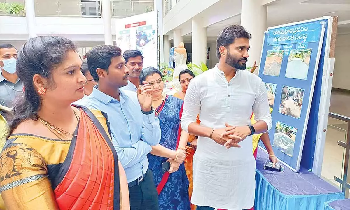 MP Bharat Ram, RMC Commissioner Dinesh Kumar, RUDA Chairperson Sharmila Reddy and others watching a photo exhibition on road repairs in Rajamahendravaram on Friday