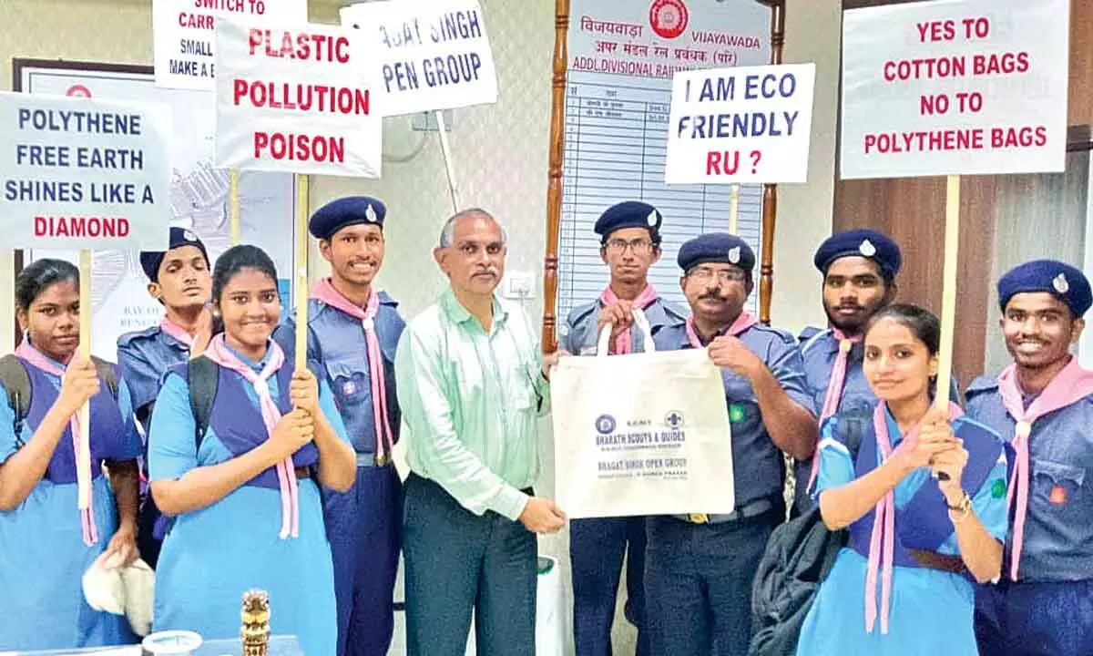Bhaghat Singh Open Group of Bharat Scouts & Guides presenting a cloth bag to the staff of divisional office in Vijayawada on Thursday