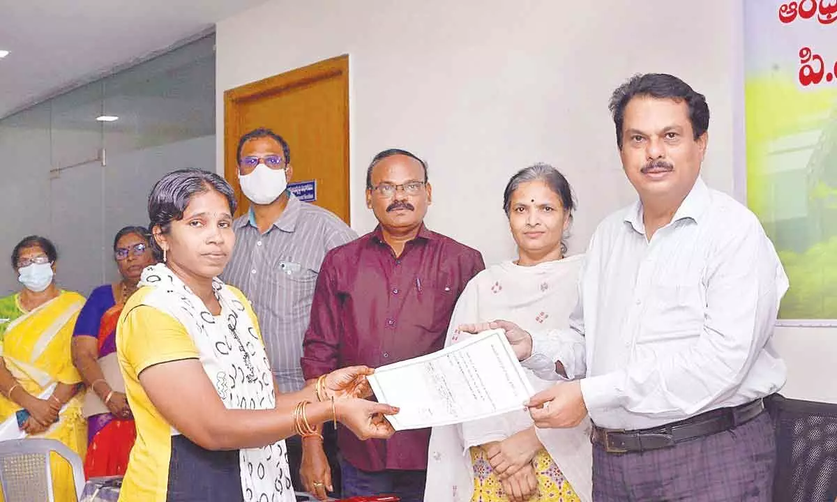 AP CRDA Additional Commissioner Aleem Basha distributing house allotment letter to a beneficiary in Tulluru on Thursday