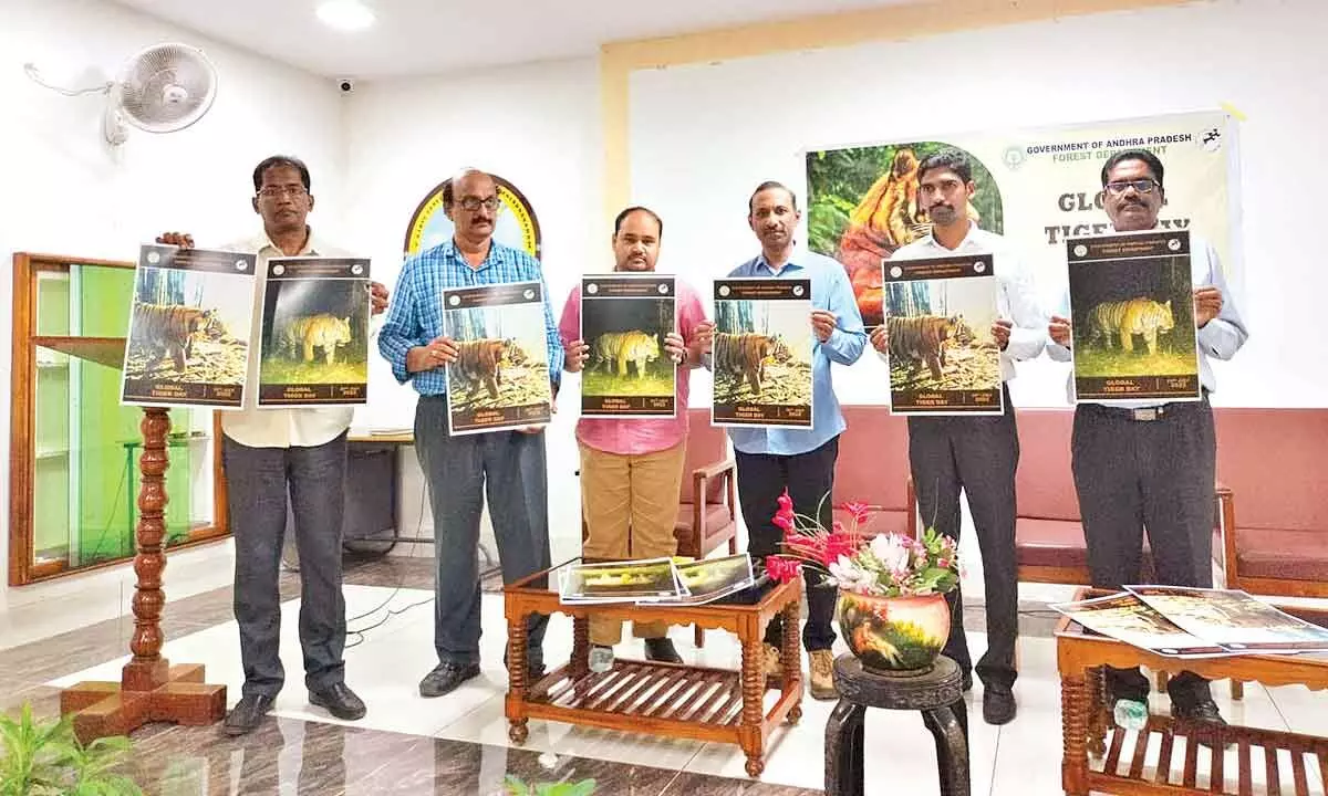 Chief Conservator of Forests S Sri Saravanan, Wildlife DFO C Selvam and others releasing posters on World Tiger Day at AP State Forest Academy in Rajamahendravaram on Friday