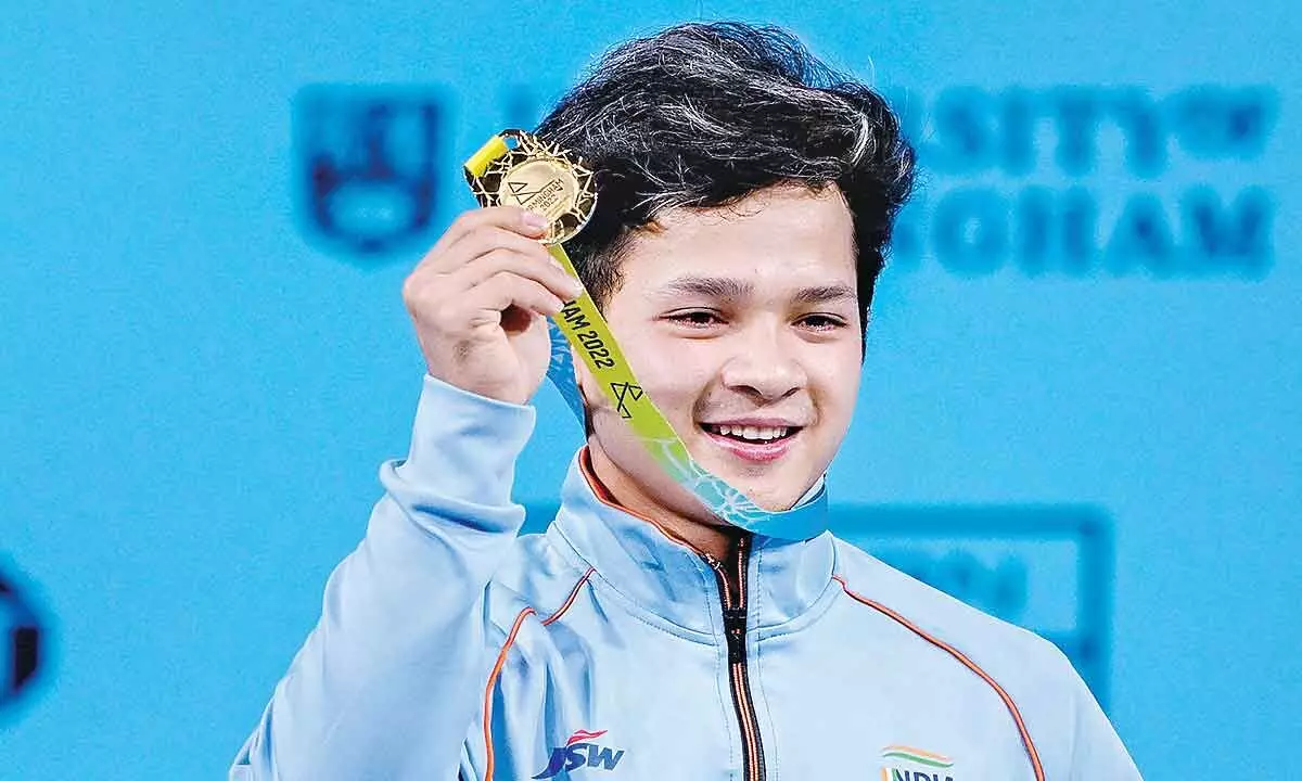 Indias Jeremy Lalrinnunga atop the podium poses for photographs after winning the gold medal in the mens 67kg category weightlifting event, at the Commonwealth Games 2022 (CWG), in Birmingham, UK on Sunday