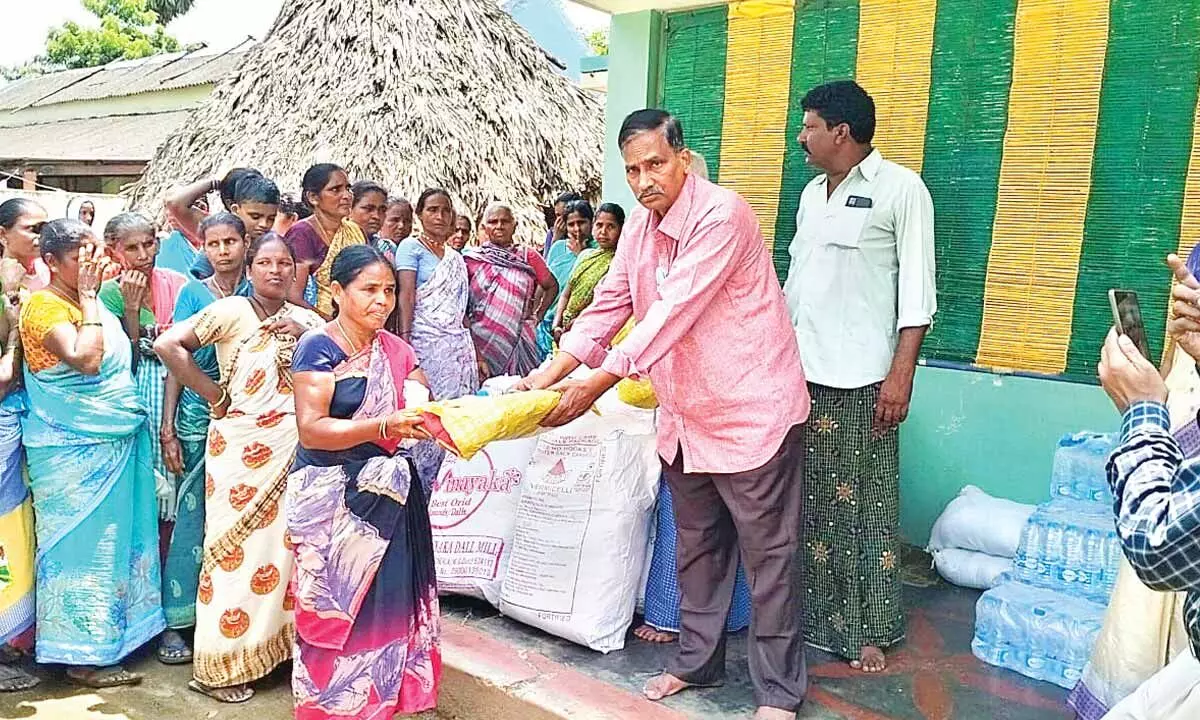 A member of Repaka family distributing clothes to a flood victim of Gannerukoyalapadu village on Tuesday