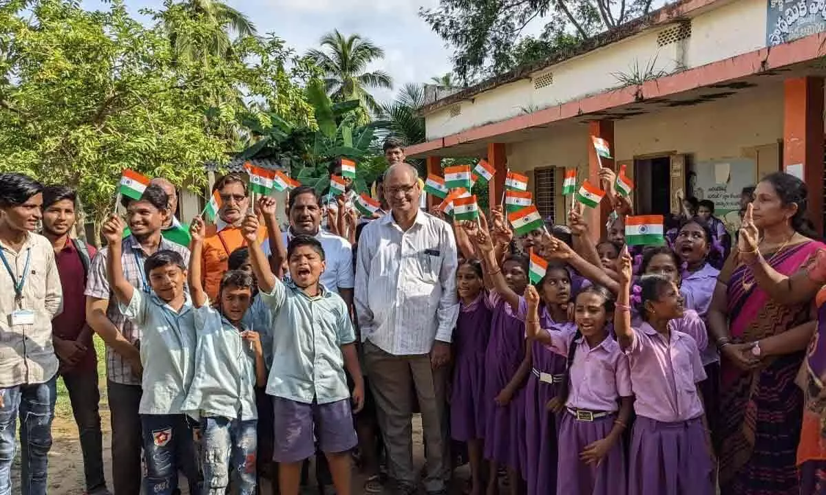 Dr M Jagapati Raju, Principal of SRKR Engineering College, along with the students of primary school at Pedda Ameram village on Wednesday