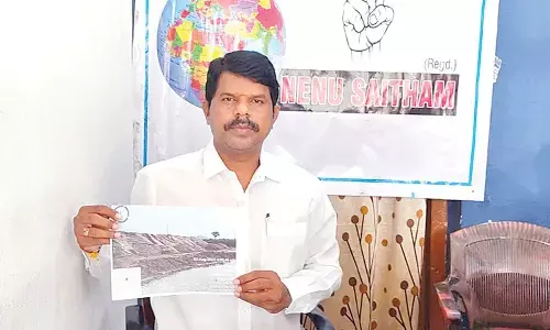 Nenu Saitam Social organisation president Diddi Praveen Kumar showing a photo graph of illegal sand dump in Manganoor in Narayanpet district on Wednesday