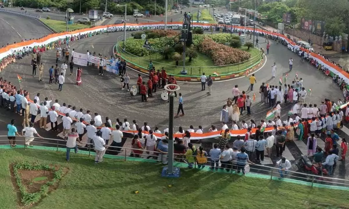 Volunteers, students, officials and people participating in Azadi Ka Amrit Mahotsav celebrations by holding a 300-mt-long national flag in Visakhapatnam on Sunday