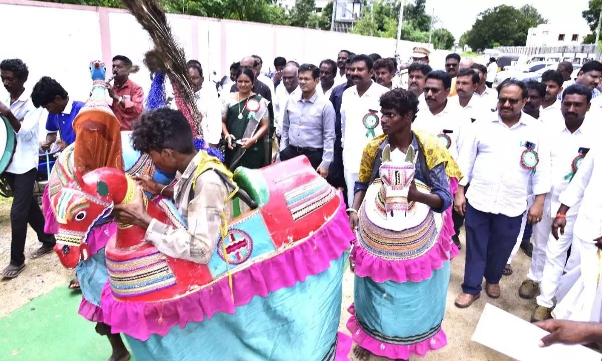 Prakasam district Collector AS Dinesh Kumar and others observing the performance of tribal artistes at World Tribal Day celebrations in Ongole on Tuesday