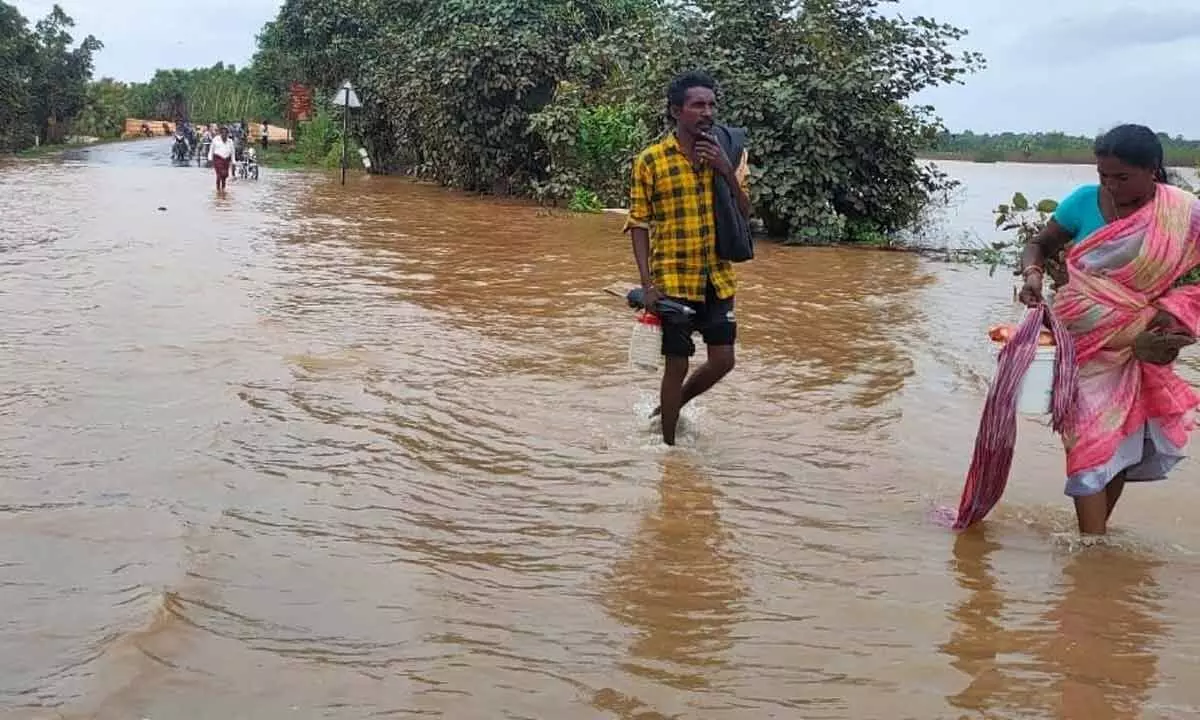 The flood water overflowing on the road between the villages of Kannayaguem and Turubaka in Dummugudem mandal in Kothagudem district on Wednesday