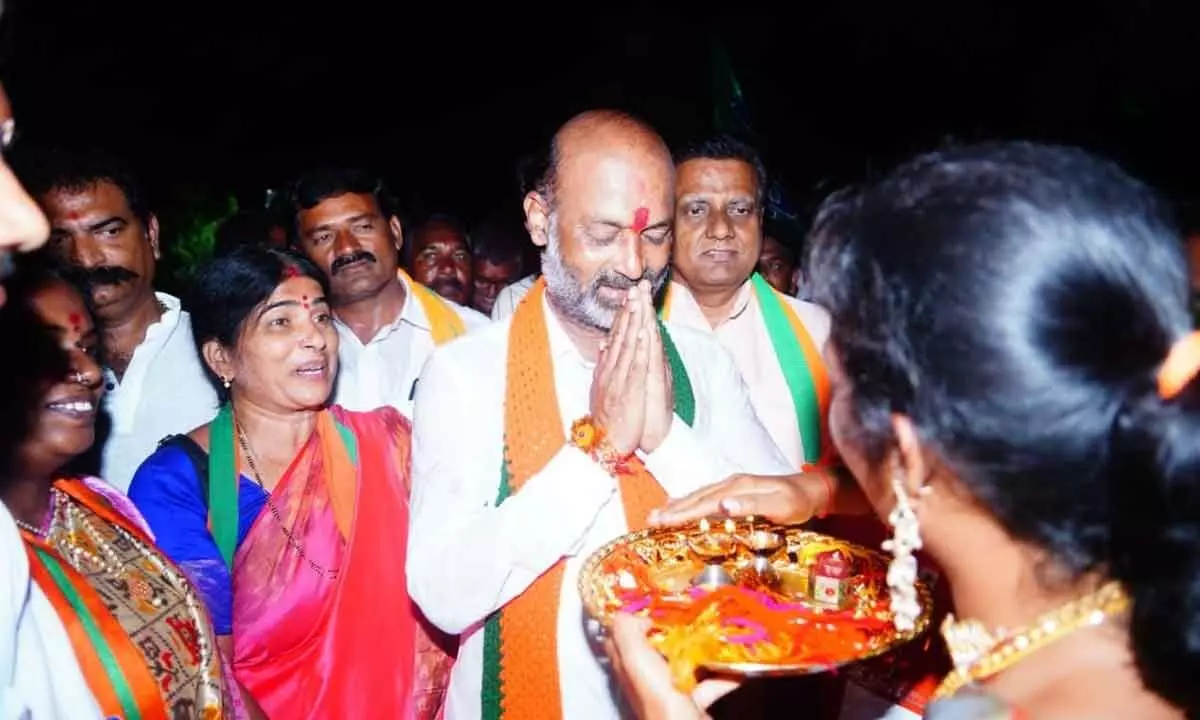 A woman offers Harathi after tying  Rakhi to BJP State chief Bandi Sanjay during his padayatra in Bhongir district on Friday