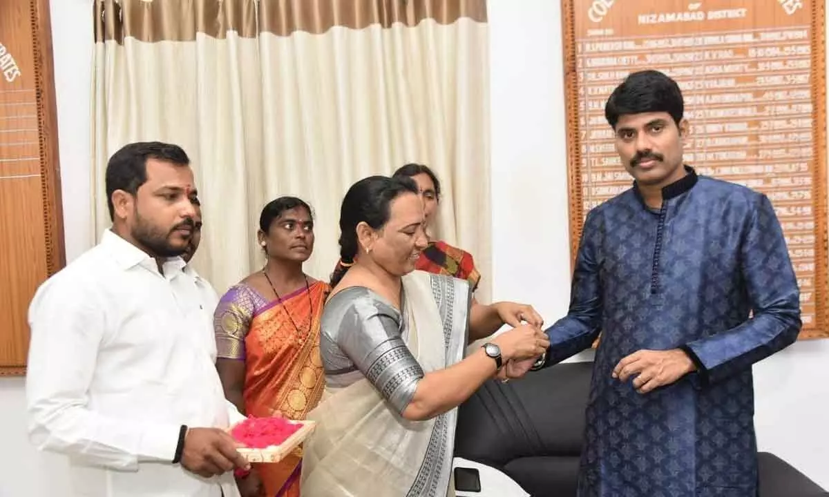 A woman tying rakhi to Collector Narayana Reddy in Nizamabad on Friday