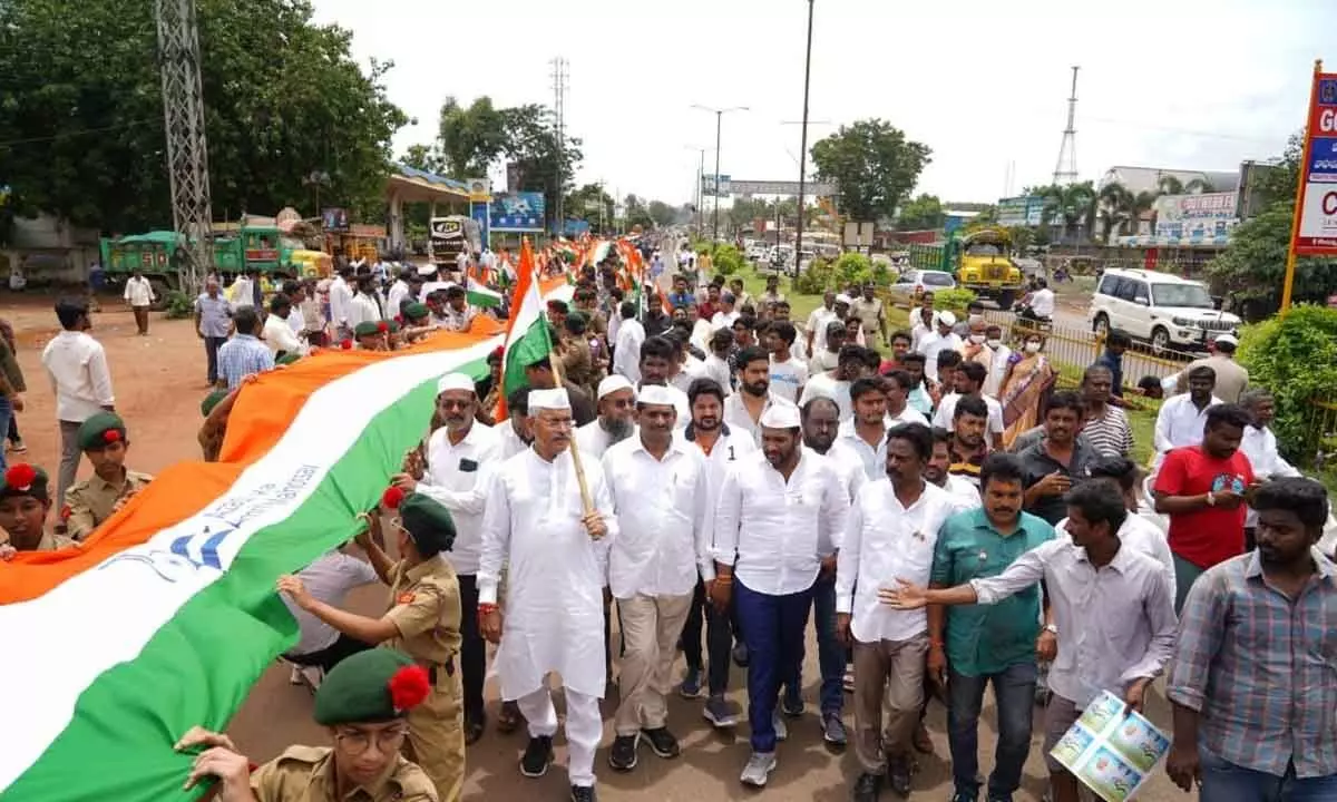 BC Welfare Minister Chelluboyina Venu and other leaders participating in a rally holding 5.2-km-long national flag in Rajamahendravaram on Friday