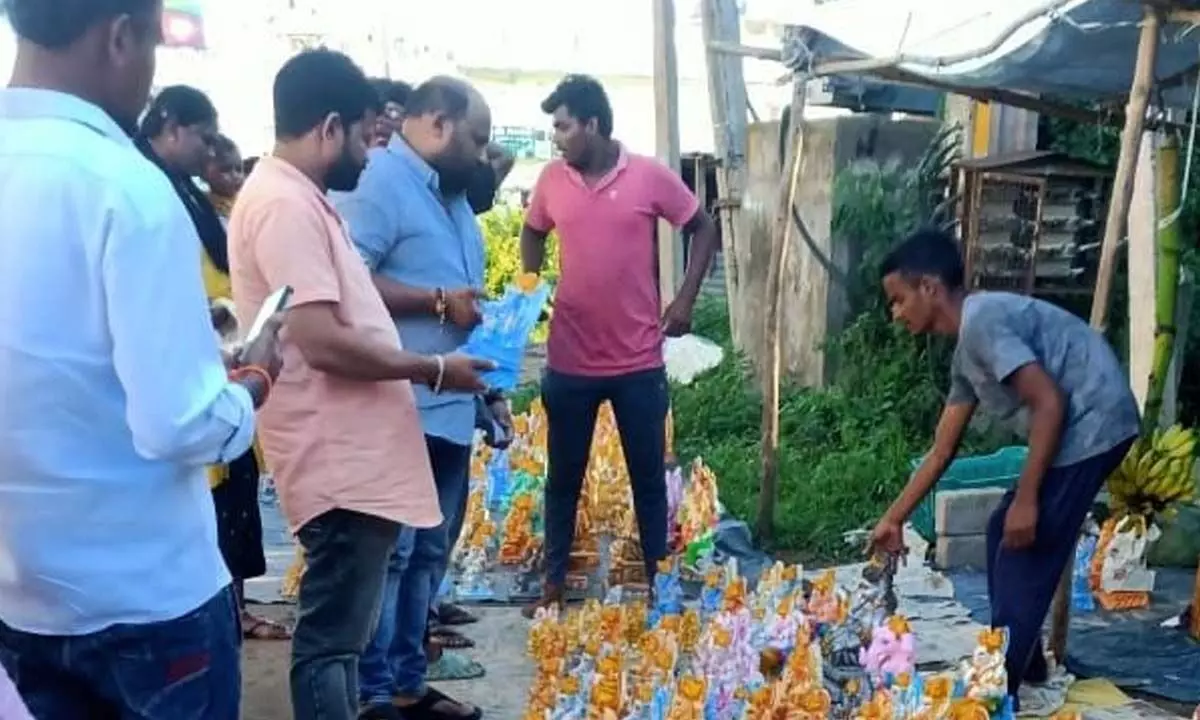 Devotees rush witnessed at a stall to purchase Ganesh idols made of plastic products, artificial colours in Srikakulam on Tuesday