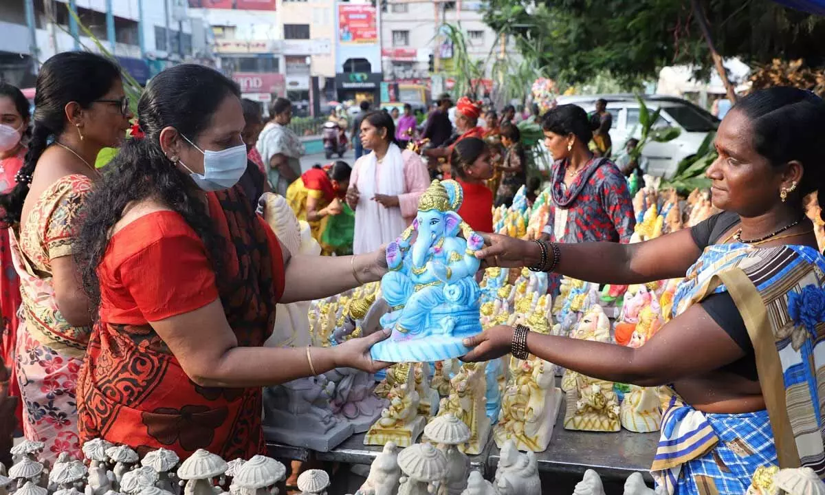 Women buying Ganesh idols on the eve of Vinayaka Chaviti at TUDA office road in Tirupati on Tuesday