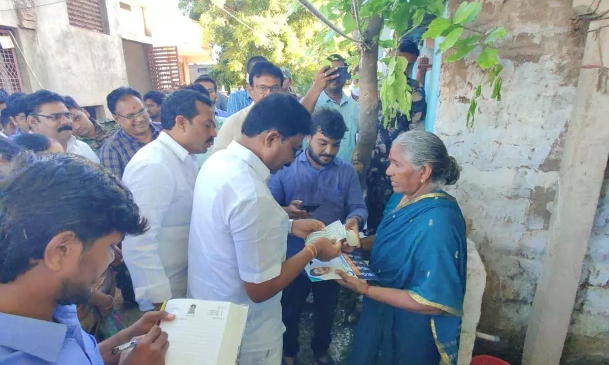 Minister Dr Audimulapu Suresh distributing pension to an old-aged woman in Yerragondappalem on Thursday morning