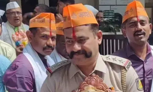 Police Inspector J M Kalimirchi carrying a Ganesha statue during the installation day on Gokul Road.