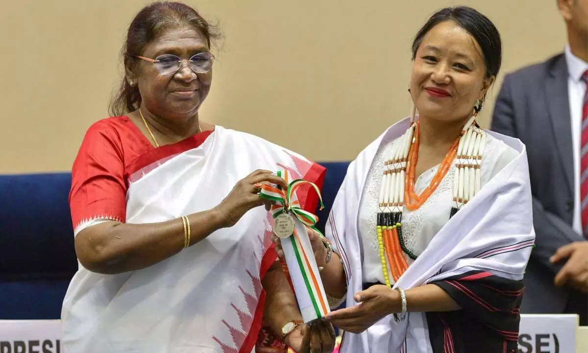 President Droupadi Murmu presents an award to a teacher at a function on Teachers Day at Vigyan Bhavan, in New Delhi on  Monday