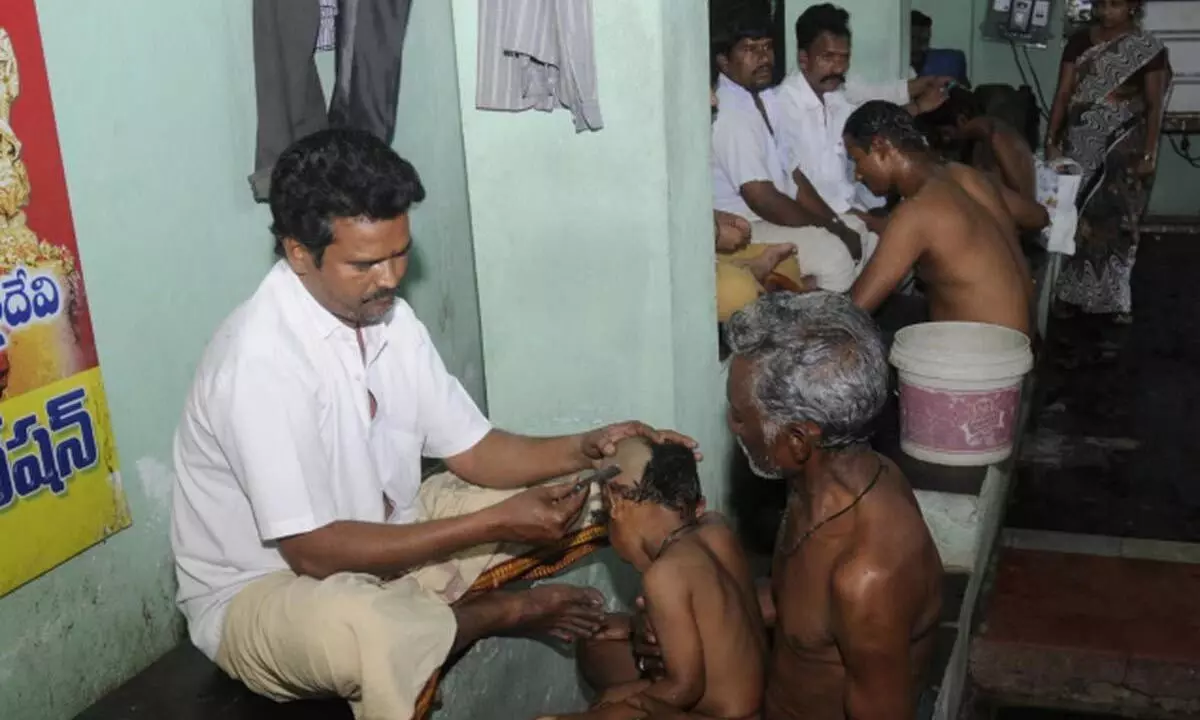 File photo of barbers at work at the tonsuring hall of Sri Durga Malleswara Swamyvarla Devasthanam at Durga ghat in Vijayawada