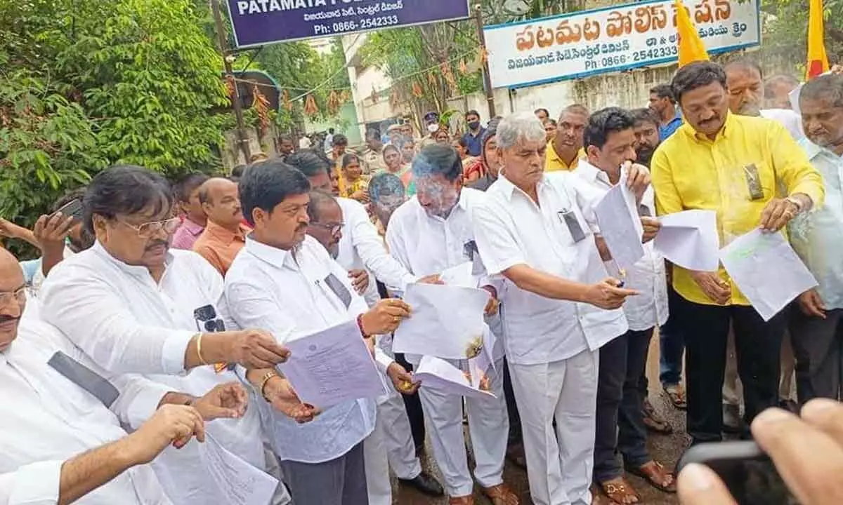 TDP leaders burning copies of the FIR in front of Patamata police station in Vijayawada on Thursday