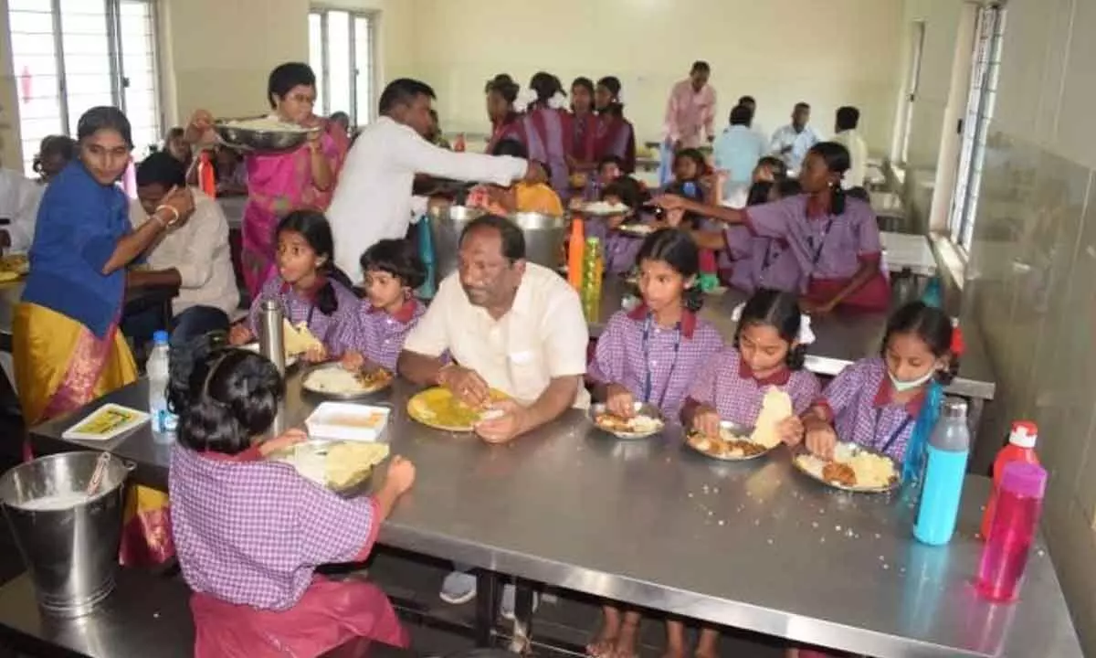 Welfare Minister K Eshwar having lunch with students at Gurukul (girls) School at Mallapur in Peddapalli district on Friday.