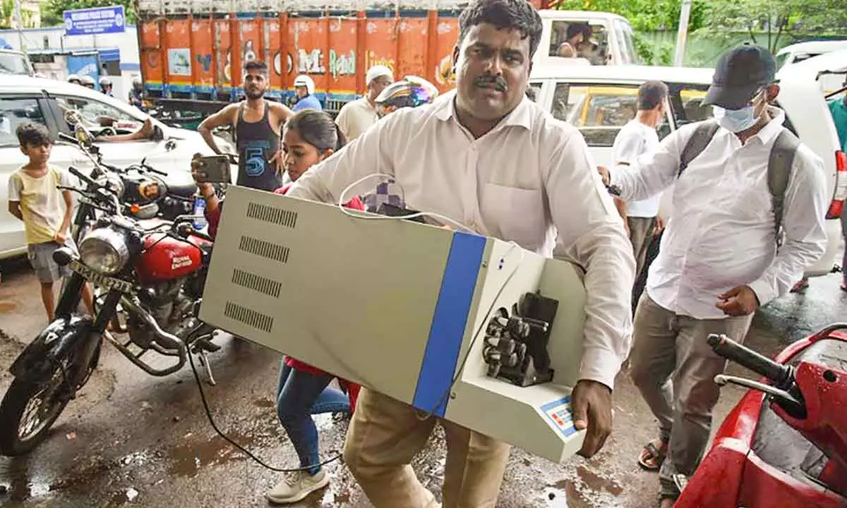 An official carries a cash counting machine during a raid, where ED seized over Rs 17 crore cash as part of a money-laundering case against promoters of alleged fraud mobile gaming app, at Garden Reach area in Kolkata on Saturday