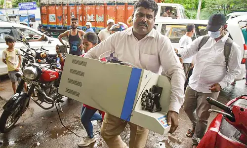 An official carries a cash counting machine during a raid, where ED seized over Rs 17 crore cash as part of a money-laundering case against promoters of alleged fraud mobile gaming app, at Garden Reach area in Kolkata on Saturday