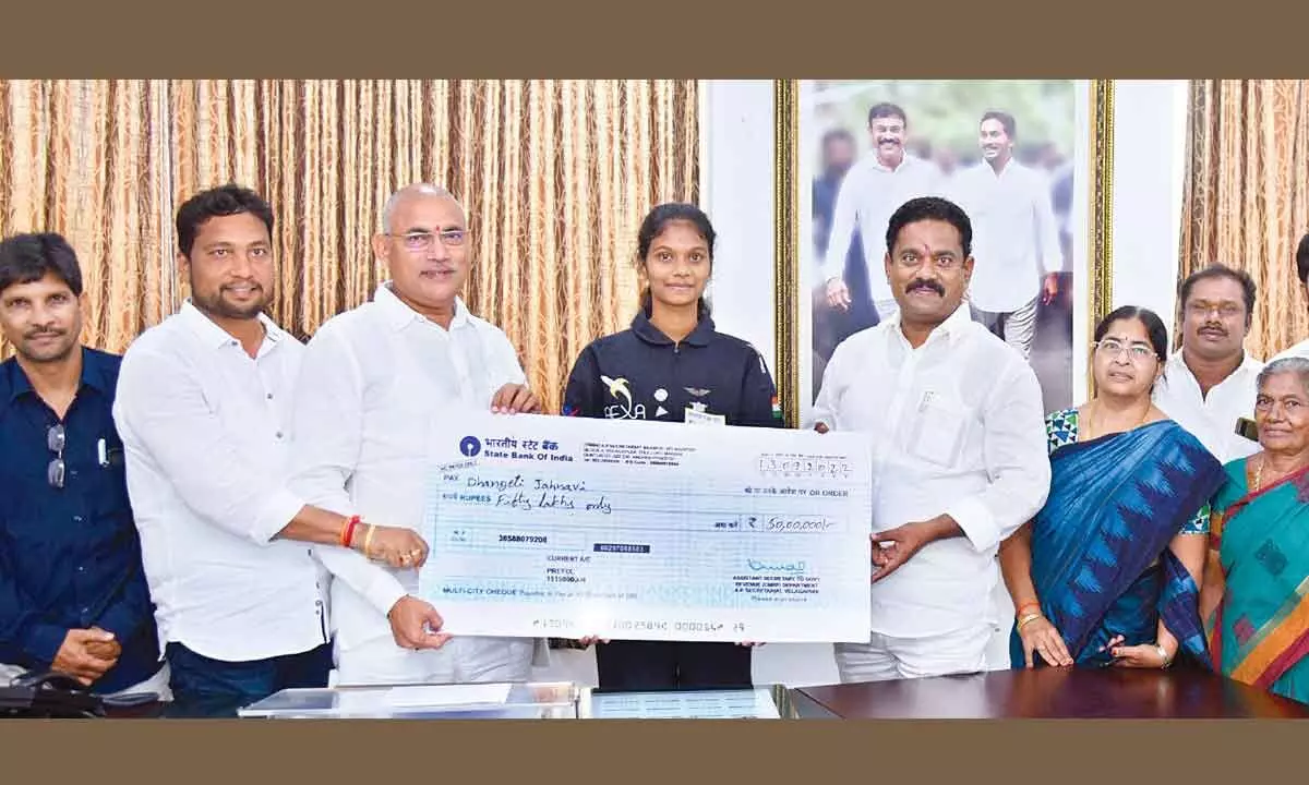 Minister for Information and Public Relations Ch Srinivasa Venugopalakrishna handing over a cheque for Rs 50 lakh to engineering third year student D Jahnavi at the Secretariat at Velagapudi on Wednesday