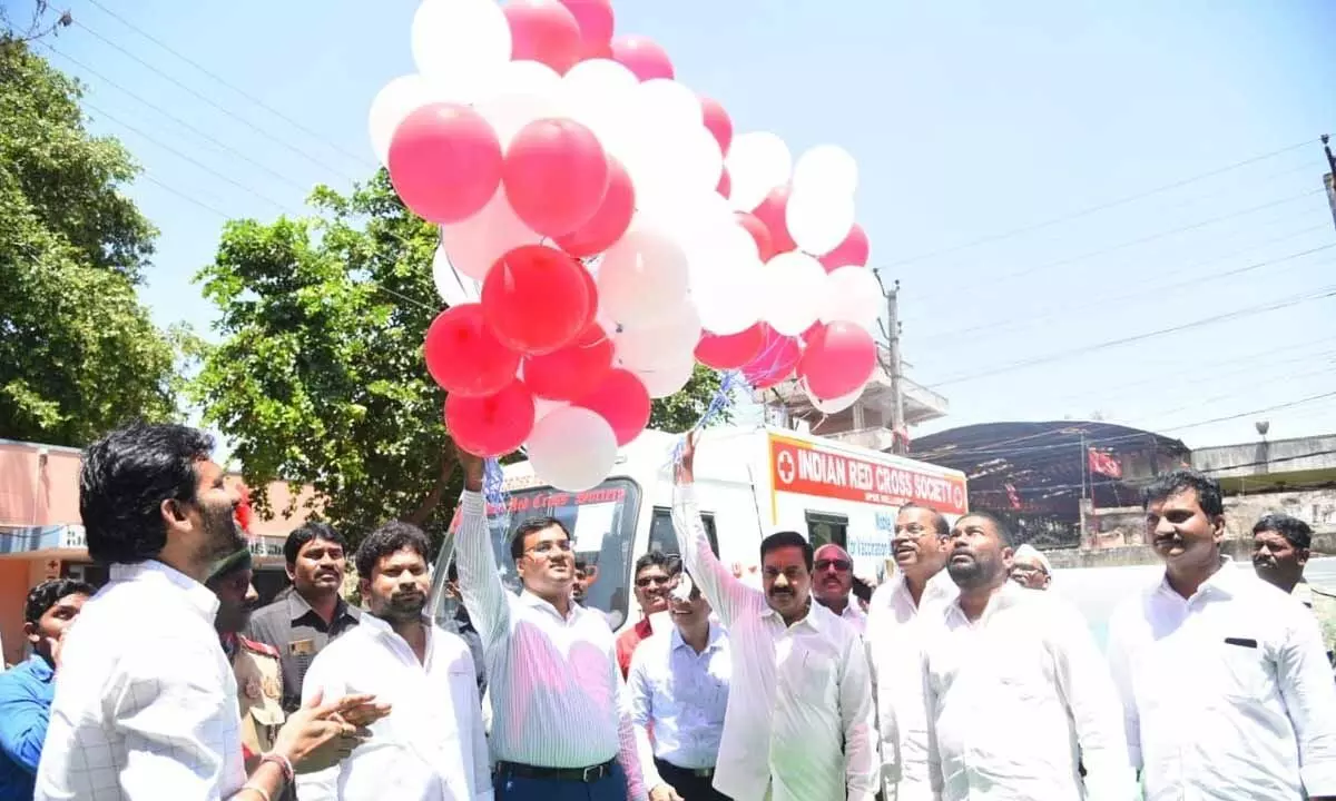 Agriculture Minister K Govardhan Reddy releasing ballons in air after inaugurating mobile vans for blood donation and vaccination, in Nellore on Sunday