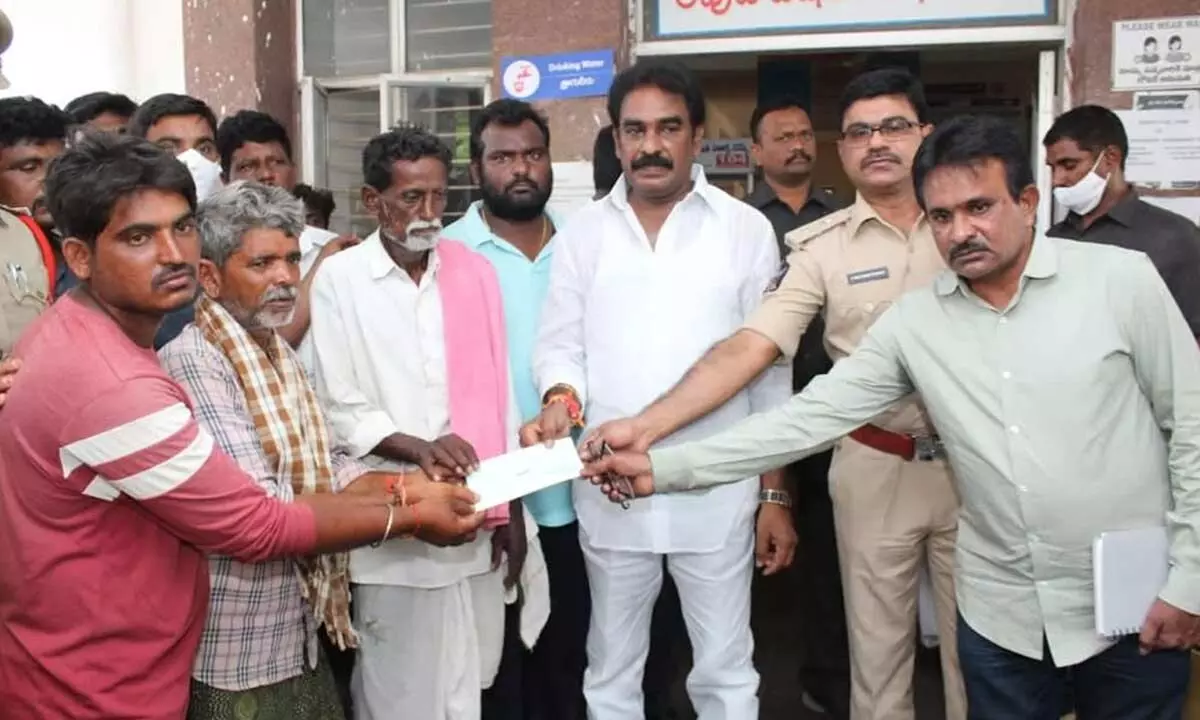 Government Whip Pinnelli Rama Krishna Reddy and Palnadu district SP Ravisankar Reddy handing over a cheque to the kin of the victim in Macherla on Sunday