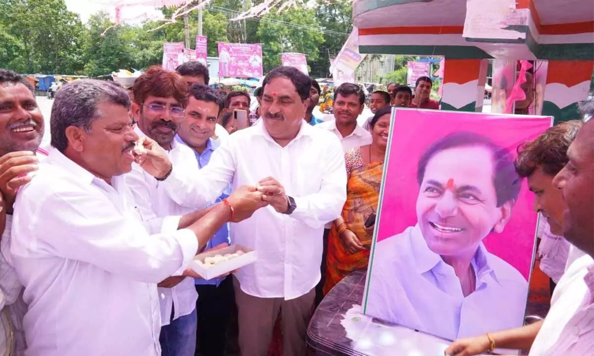 Minister for Panchayat Raj and Rural Development Errabelli Dayakar Rao distributing sweets to tribal leaders at Palakurthi in Jangaon district on Sunday