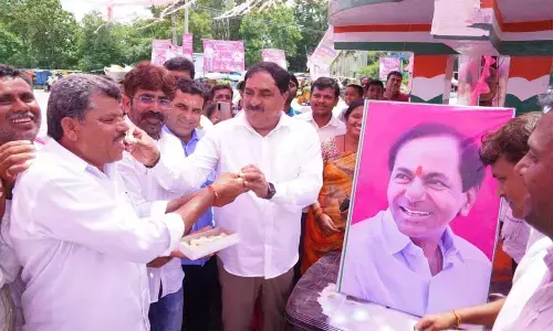 Minister for Panchayat Raj and Rural Development Errabelli Dayakar Rao distributing sweets to tribal leaders at Palakurthi in Jangaon district on Sunday