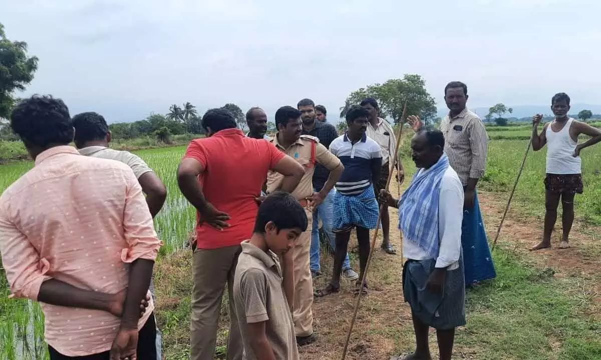 Police and forest department personnel at the agricultural field where pug marks of the leopard were found in Velugodu mandal on Sunday