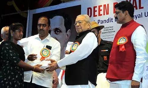 Governor Biswabhusan Harichandan giving away a hearing aid to a girl at a programme at Siddhartha Auditorium in Vijayawada on Sunday	Photo: Ch Venkata Mastan