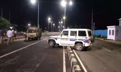 A parked police vehicle being pushed over a divider following an accident in Visakhapatnam