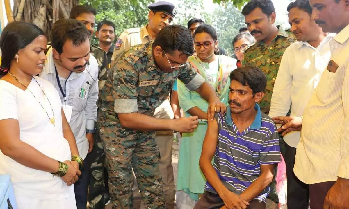SP Dr G Vineeth giving a booster dose of Covid vaccine to a tribal man during the free health camp conducted in Manuguru agency on Wednesday