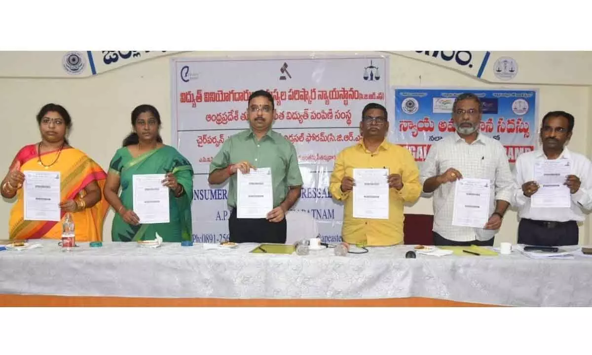 District Judge Kalyan Chakravarthi, CGRF chairman Satyanarayana and others releasing pamphlets of toll free number in Vizianagaram on Thursday