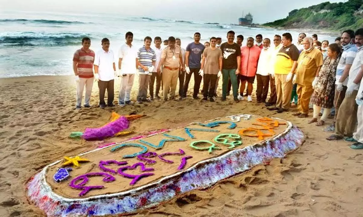 District officials at the sand art at RK Beach in Visakhapatnam on Sunday
