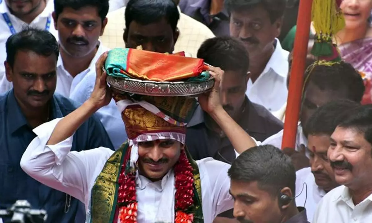 Chief Minister Y S Jagan Mohan Reddy carrying silk clothes to offer them to the presiding deity at Kanaka Durga temple on Indrakeeladri  in Vijayawada on Sunday Photo: Ch V Mastan