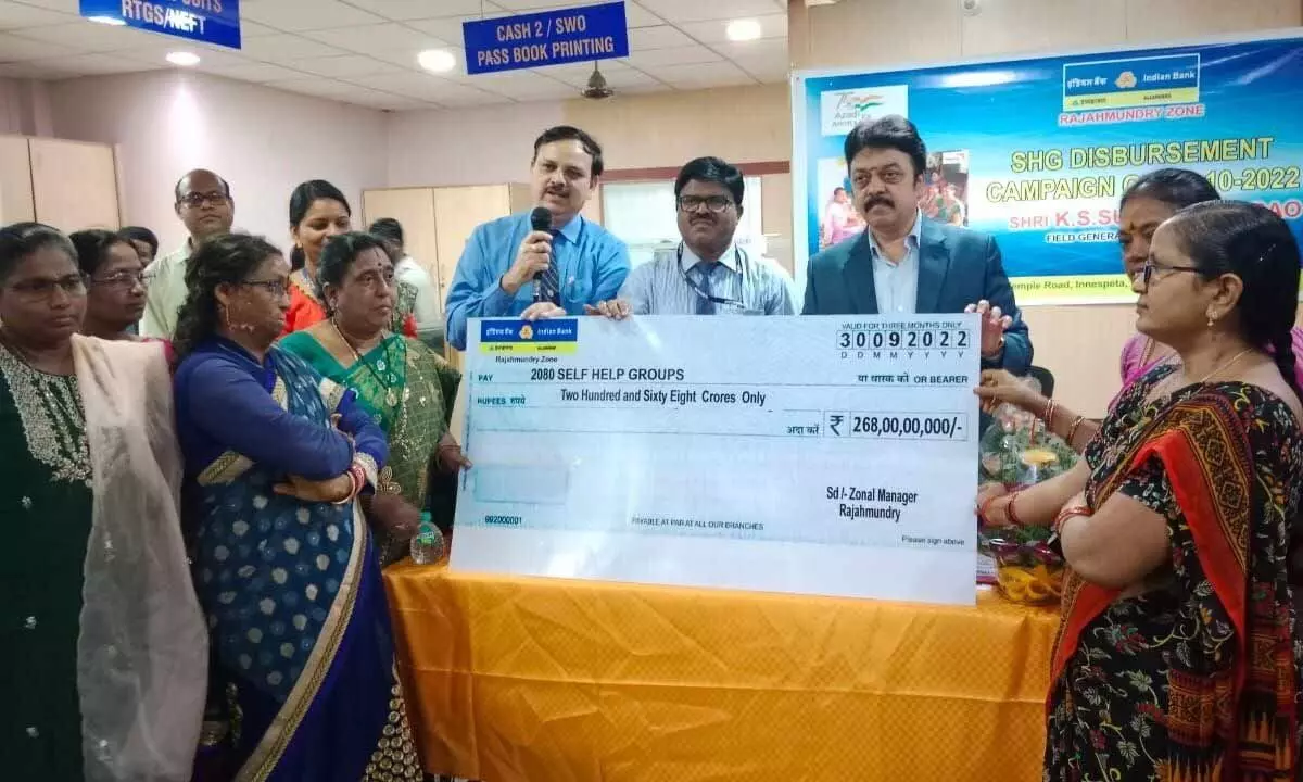 Indian Bank local branch Field General Manager SKS Sudhakar Rao and other officials presenting a cheque to DWCRA members at a programme at Indian Bank in Rajamahendravaram